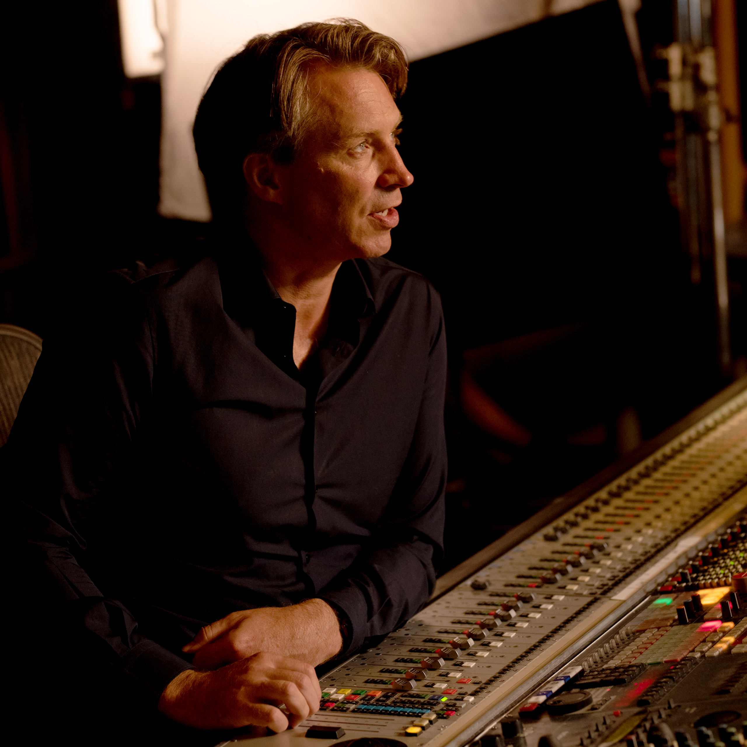 Music producer in a recording studio with audio equipment
